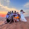 group photo of tourists on a high dune desert