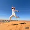guest-jumping-dune-blue-sky-dubai - morning desert safari with quad biking - website handled by mustajabhub.com