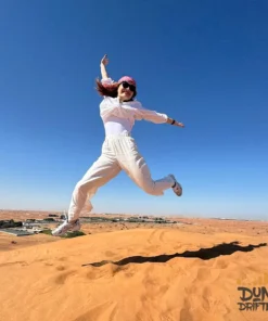 guest-jumping-dune-blue-sky-dubai - morning desert safari with quad biking - website handled by mustajabhub.com