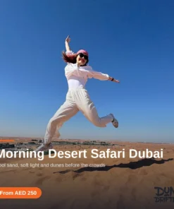Guest jumping on a red dune under blue sky on a Dubai morning desert safari